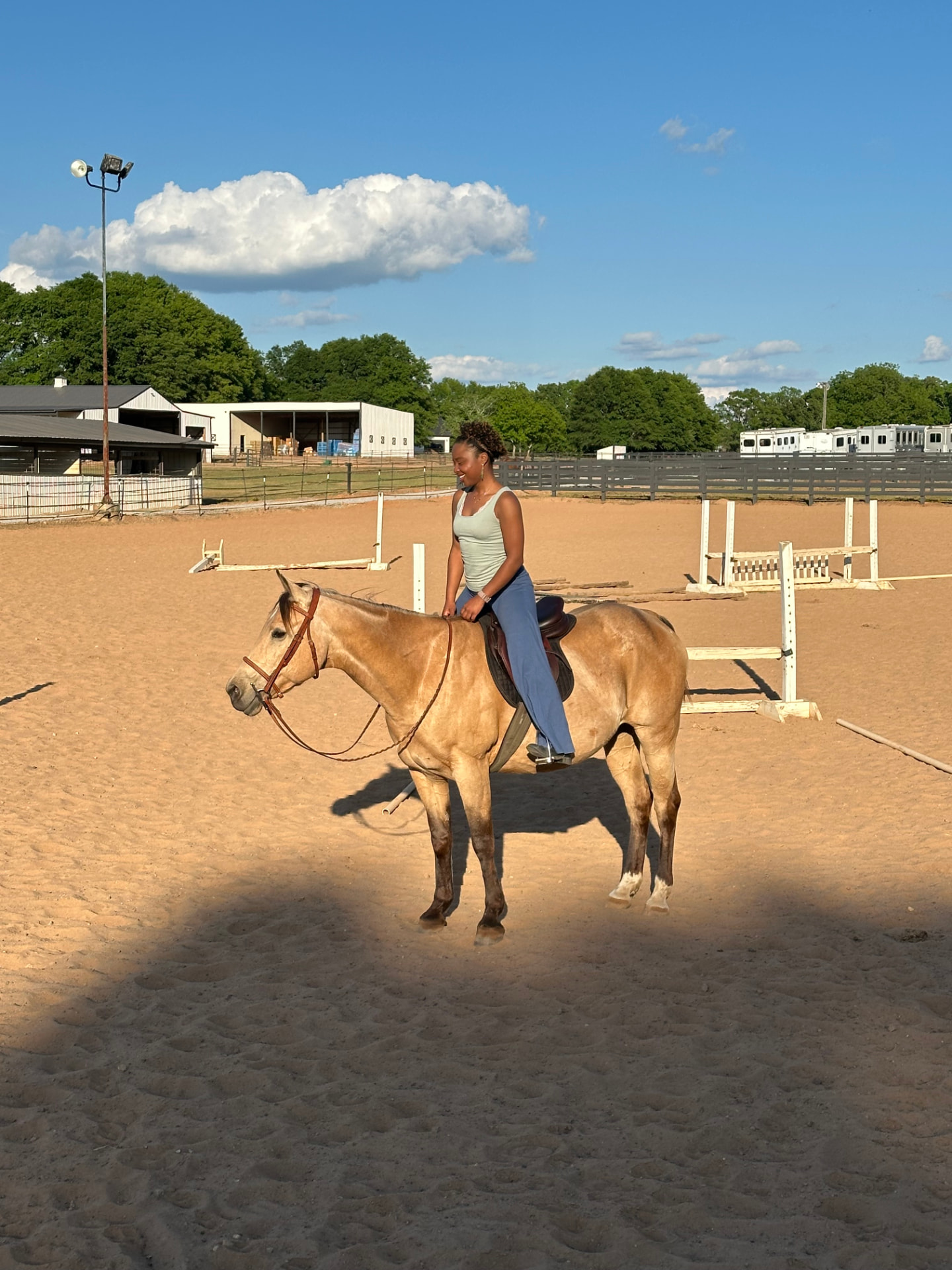 Raine Cox riding her horse Breezy in an outdoor arena