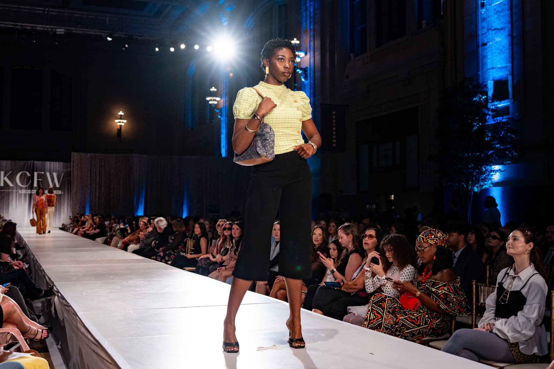Model on the KCFW runway in a green checked Range & Reverie top and black culottes
